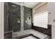 Modern shower boasts dark tile, bench, and glass enclosure at 408 E Silverwood Dr, Phoenix, AZ 85048