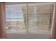 A bright window view showcases desert landscaping and blinds for privacy at 408 E Silverwood Dr, Phoenix, AZ 85048