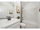 Bright bathroom with a white vanity, artwork, and a bathtub with marble wall at 42440 W Peters Dr, Maricopa, AZ 85138
