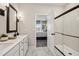 Bright bathroom with double vanity, glass enclosed shower, and view into bedroom at 42440 W Peters Dr, Maricopa, AZ 85138
