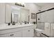 Well-lit bathroom featuring a double vanity, sleek fixtures, and a glass-enclosed shower at 42440 W Peters Dr, Maricopa, AZ 85138