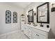 Bright bathroom with a double vanity, black accents, and modern mirrors at 42440 W Peters Dr, Maricopa, AZ 85138