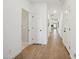 Long hallway with wood-look flooring, doors leading to various rooms, and neutral wall paint at 42440 W Peters Dr, Maricopa, AZ 85138