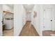 Well-lit hallway with wood floors, white doors, and decorative wall accents at 42440 W Peters Dr, Maricopa, AZ 85138
