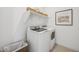 Laundry area with front load washer and dryer, shelf, storage baskets, and decorative print at 42440 W Peters Dr, Maricopa, AZ 85138