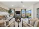 Inviting living room with hardwood floors, neutral furniture, and an entertainment center at 42440 W Peters Dr, Maricopa, AZ 85138