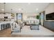 Open-concept living space with modern lighting, neutral tones, and hardwood-style flooring at 42440 W Peters Dr, Maricopa, AZ 85138