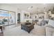 Living room with cozy seating arrangement and seamless transition to the outdoor patio and kitchen at 42440 W Peters Dr, Maricopa, AZ 85138