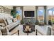 Relaxing living room featuring hardwood floors, neutral furniture, and a large-screen TV at 42440 W Peters Dr, Maricopa, AZ 85138