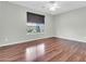 This empty bedroom features a ceiling fan, a window, and dark brown wood floors, creating a modern aesthetic at 4323 S Ranger Trl, Gilbert, AZ 85297