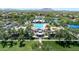 Aerial view of a pristine community pool with a clubhouse, surrounded by lush greenery and scenic views at 4323 S Ranger Trl, Gilbert, AZ 85297