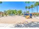 A spacious community playground featuring multiple play structures, set against a backdrop of palm trees and picnic shelters at 4323 S Ranger Trl, Gilbert, AZ 85297
