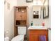 Compact bathroom with a combination toilet and vanity, featuring wood cabinetry at 4403 N 56Th Dr, Phoenix, AZ 85031
