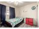 Simple bedroom with a single bed, colorful bedding, and functional storage solutions at 4403 N 56Th Dr, Phoenix, AZ 85031