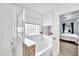 Well-lit bathroom featuring a soaking tub with mosaic tile accents and glass shower at 450 W Mountain Sage Dr, Phoenix, AZ 85045