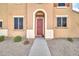 Charming home featuring a red front door framed by a white archway and accented by manicured landscaping at 450 W Mountain Sage Dr, Phoenix, AZ 85045