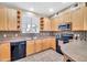 Cozy kitchen with wooden cabinets, a black appliance suite and ample counter space at 450 W Mountain Sage Dr, Phoenix, AZ 85045