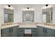 Bright bathroom featuring dual sinks, marble countertops, and decorative mirrors with modern lighting at 5520 E Muriel Dr, Scottsdale, AZ 85254