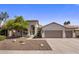 Charming single-story home featuring a well-manicured yard, desert landscaping, and a three-car garage at 5520 E Muriel Dr, Scottsdale, AZ 85254