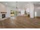 Expansive open concept featuring a modern fireplace, wood-look floors, and access to kitchen at 5520 E Muriel Dr, Scottsdale, AZ 85254