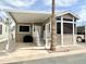 Charming manufactured home with covered parking, desert landscaping, and a welcoming front porch entry at 591 S Ironstone Dr, Apache Junction, AZ 85119