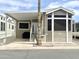 Charming manufactured home with covered parking, desert landscaping, and a welcoming front porch entry at 591 S Ironstone Dr, Apache Junction, AZ 85119