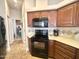 Well-maintained kitchen with dark appliances and wood cabinets, leading to other areas of the home at 591 S Ironstone Dr, Apache Junction, AZ 85119