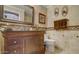 Well-appointed bathroom with a rich wood vanity, decorative mirror, and tiled walls for a comfortable and stylish retreat at 6900 E Princess Dr # 1176, Phoenix, AZ 85054