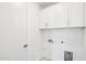 A modern laundry room featuring white cabinets and neutral walls at 10241 E Ursula Ave, Mesa, AZ 85212