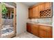 Inside bar area with natural wood cabinetry, a sink, and a wine rack plus view of the backyard at 10267 E Cinder Cone Trl, Scottsdale, AZ 85262