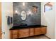 Bathroom with black countertop, floating vanity, and decorative wall mirror at 10267 E Cinder Cone Trl, Scottsdale, AZ 85262