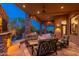 This covered patio has stone pillars and comfortable seating areas for outdoor relaxation at 10267 E Cinder Cone Trl, Scottsdale, AZ 85262