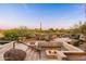 Unique sunken fire pit area with built-in seating, stone accents, and views of the desert landscape at 10267 E Cinder Cone Trl, Scottsdale, AZ 85262