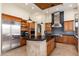 The kitchen features modern stainless steel appliances, wood cabinetry, and a spacious island with a black countertop at 10267 E Cinder Cone Trl, Scottsdale, AZ 85262