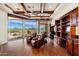 Bright living area features wood beam ceiling, hardwood floors, and oversized windows showcasing stunning desert landscape at 10267 E Cinder Cone Trl, Scottsdale, AZ 85262