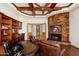 Inviting living room boasts a stone fireplace, built-in bookshelves, and wood-beamed ceilings at 10267 E Cinder Cone Trl, Scottsdale, AZ 85262