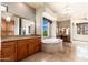 This primary bath includes dual vanities, a soaking tub, and plenty of natural light from large windows at 10267 E Cinder Cone Trl, Scottsdale, AZ 85262