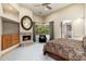 Primary bedroom with a fireplace, a ceiling fan, and an arched doorway to the bathroom at 10267 E Cinder Cone Trl, Scottsdale, AZ 85262