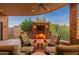 This covered patio has a stone fireplace and comfortable outdoor seating for entertaining at 10267 E Cinder Cone Trl, Scottsdale, AZ 85262