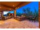 This covered outdoor kitchen has a built-in grill, stone counter, and lovely backyard views at 10267 E Cinder Cone Trl, Scottsdale, AZ 85262