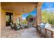 Spacious covered patio features stone fireplace, built-in grill, seating, and brick pavers for stylish outdoor living at 10267 E Cinder Cone Trl, Scottsdale, AZ 85262