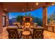 Inviting outdoor area with stone fireplace, comfortable seating, and a ceiling fan for relaxed evenings at 10267 E Cinder Cone Trl, Scottsdale, AZ 85262