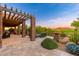 Expansive covered patio featuring stone columns, seating, outdoor kitchen, and scenic views of the surrounding landscape at 10267 E Cinder Cone Trl, Scottsdale, AZ 85262