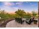 Beautiful outdoor patio with green seating, wrought iron trim, views, and brick pavers at 10267 E Cinder Cone Trl, Scottsdale, AZ 85262