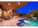 Beautiful outdoor living space featuring a shimmering pool and covered patio with stone pillars at 10267 E Cinder Cone Trl, Scottsdale, AZ 85262