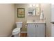 Cozy bathroom with white vanity, toilet, and framed artwork on the wall at 10330 W Thunderbird Blvd # A301, Sun City, AZ 85351