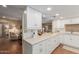 Spacious kitchen with white cabinetry, hardwood floors, and an open view to the adjacent living and dining areas at 10330 W Thunderbird Blvd # A301, Sun City, AZ 85351