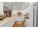 Well-lit kitchen with white cabinets, hardwood floors, modern appliances, and an open layout flowing into the living area at 10330 W Thunderbird Blvd # A301, Sun City, AZ 85351