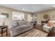 Cozy living room featuring a plush sofa, decorative pillows, hardwood floors, and an open view to the kitchen at 10330 W Thunderbird Blvd # A301, Sun City, AZ 85351