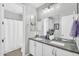 Well-lit bathroom featuring double sinks, a large mirror, and white cabinets for ample storage at 10353 E Trillium Ave, Mesa, AZ 85212